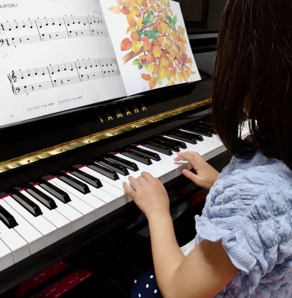初心者のピアノを弾く小学生の画像