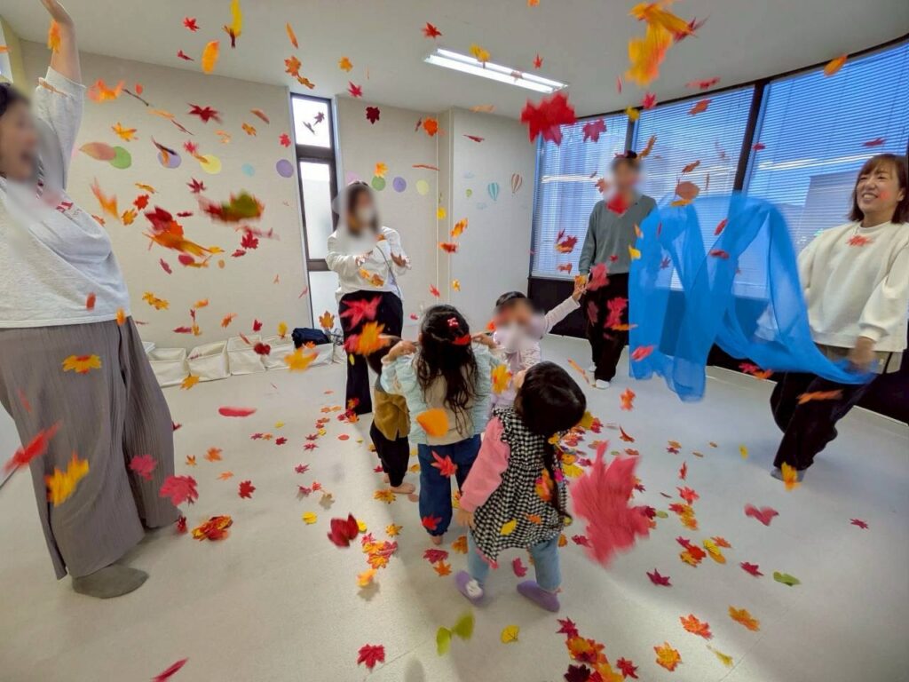 リトミックの活動で落ち葉を使い心身を解放させる子どもたちの様子3