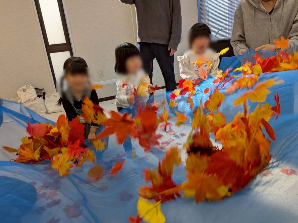 リトミックの活動で落ち葉を使い心身を解放させる子どもたちの様子２