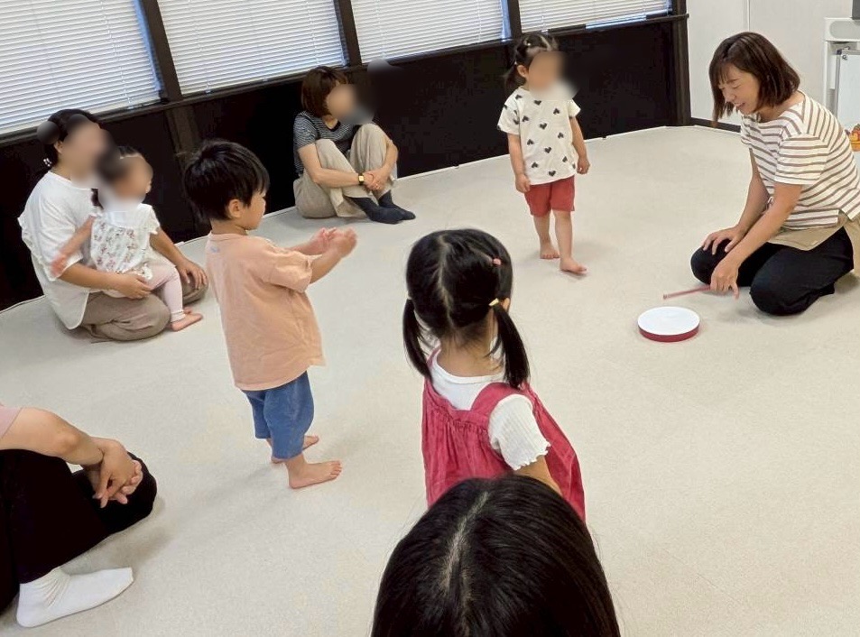 リトミックの活動で講師の模範演奏を真剣にきく子どもたちの様子